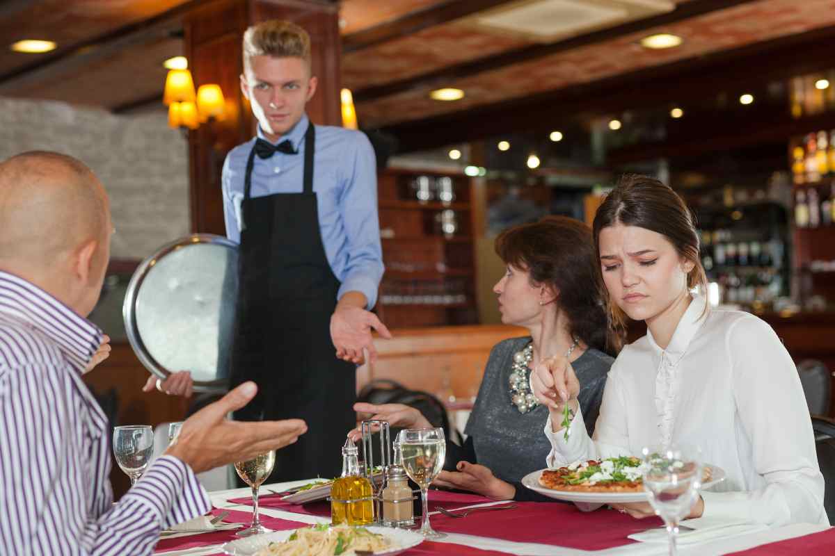 cameriere che si avvicina al tavolo al ristorante