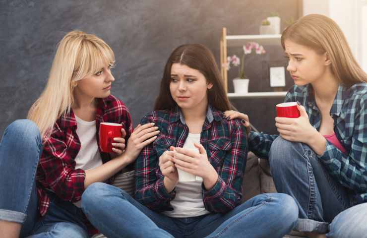 persona triste mentre gli altri parlano